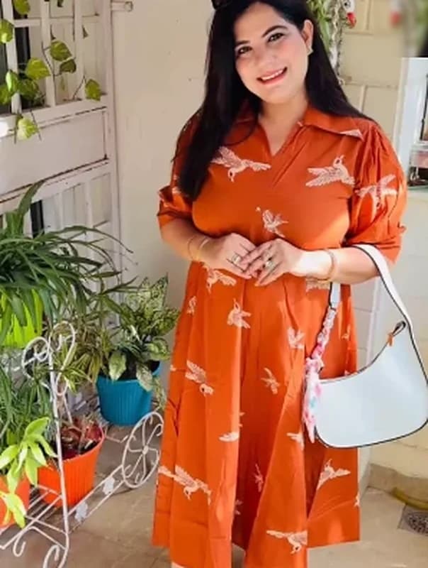 Rust orange printed dress, styled with a white shoulder bag